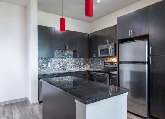 a modern kitchen with stainless steel appliances and black cabinets