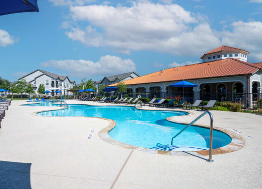 Swimming pool with sundeck and natural surrounding landscape
