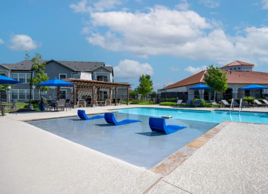 In pool sun-bathing area with natural surrounding landscape