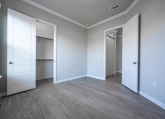 Bedroom with hard wood flooring, gray walls, and white crown molding