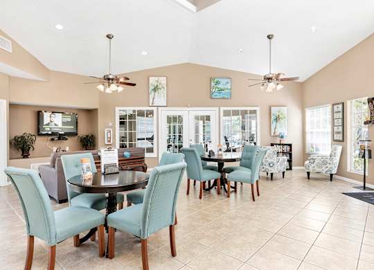 Interior of clubhouse facing a common area with chairs and tables