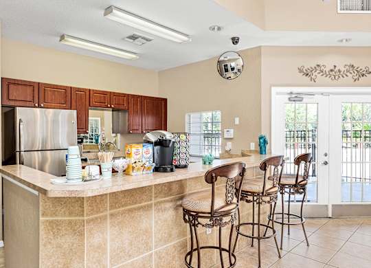 Interior or resident clubhouse facing kitchen and breakfast bar area