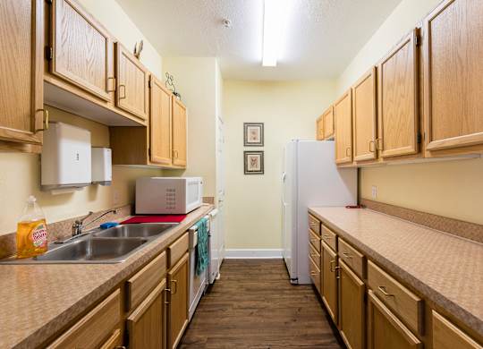 A kitchen with wooden cabinets and a white refrigerator.