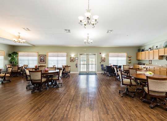 A large room with wooden floors and a chandelier hanging from the ceiling.
