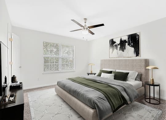 a bedroom with a bed and a ceiling fan at Caveness Farms Apartments, Wake Forest, NC 