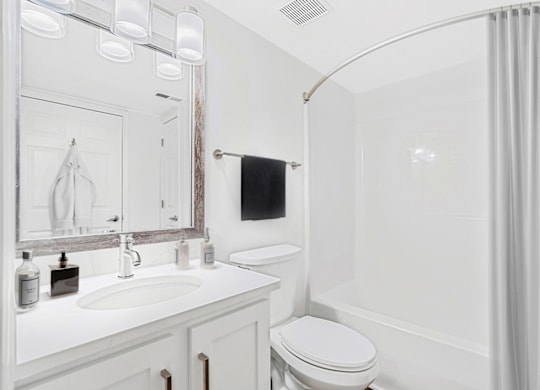 a bathroom with a white sink and toilet and a white bathtub with a shower curtain at Caveness Farms Apartments, Wake Forest, NC 