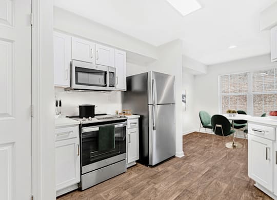 a kitchen with white cabinets and stainless steel appliances at Caveness Farms Apartments, Wake Forest, 27587 