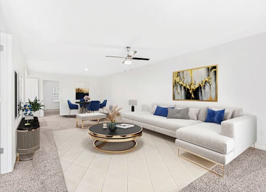 a living room with a white couch and a coffee table at Caveness Farms Apartments, Wake Forest 