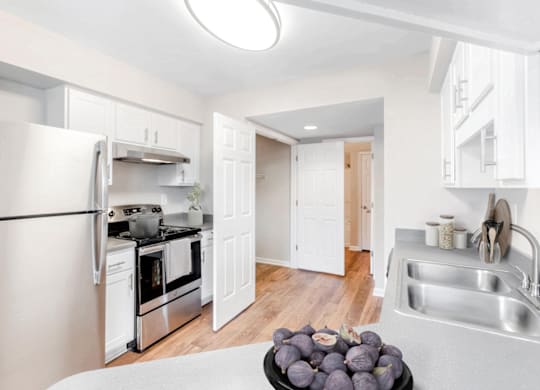 a kitchen with white cabinets and stainless steel appliances at Caveness Farms Apartments, Wake Forest, 27587 