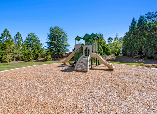 a playground with a slide and climbing equipment in a park at Caveness Farms Apartments, Wake Forest, NC 