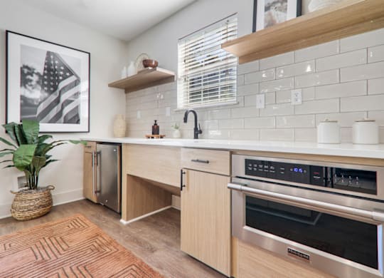 a kitchen with wooden cabinets and white countertops at Caveness Farms Apartments, Wake Forest, NC 