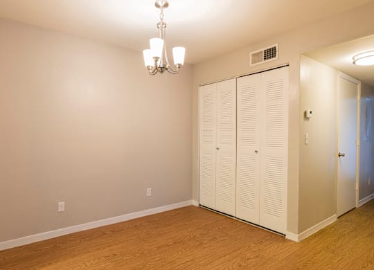 A room with a chandelier and a white cabinet.