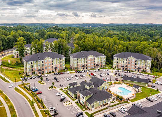 A large apartment complex with a swimming pool in the middle of a parking lot at Foxwood Apartments, North Carolina