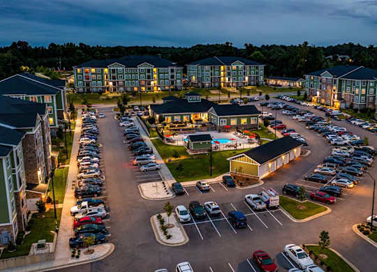 A parking lot with cars and apartment buildings in the background at Foxwood Apartments, Raleigh-Durham