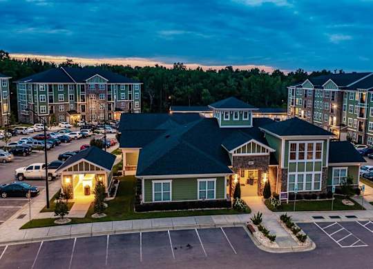 A parking lot in front of a building with a green roof at Foxwood Apartments, Raleigh-Durham, 27616