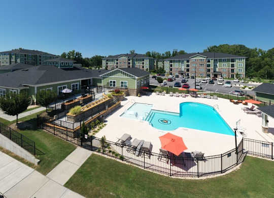 A large swimming pool surrounded by a black fence and several lounge chairs at Foxwood Apartments, Raleigh-Durham, NC, 27616