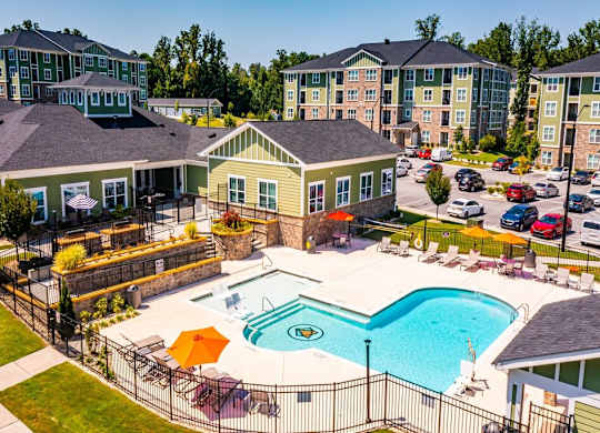 A large swimming pool surrounded by a fence and chairs at Foxwood Apartments, Raleigh-Durham, 27616