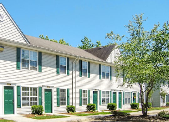 a white building with green doors and shutters