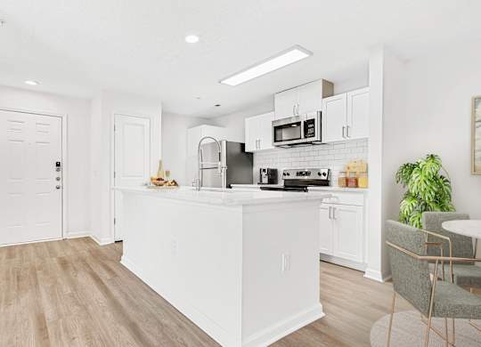 A kitchen with white cabinets and a wooden floor. at The Grayson Apartment Homes, Charlotte