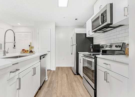 A kitchen with white cabinets and appliances. at The Grayson Apartment Homes, Charlotte, 28262