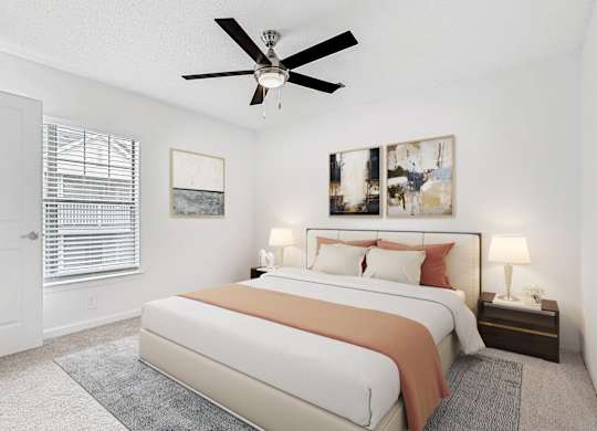A bedroom with a large bed and a ceiling fan. at The Grayson Apartment Homes, Charlotte