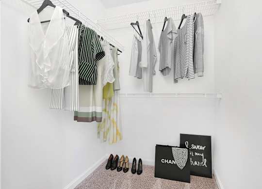 A room with clothes hanging and a pair of shoes on the floor The Grayson Apartment Homes, Charlotte, 28262