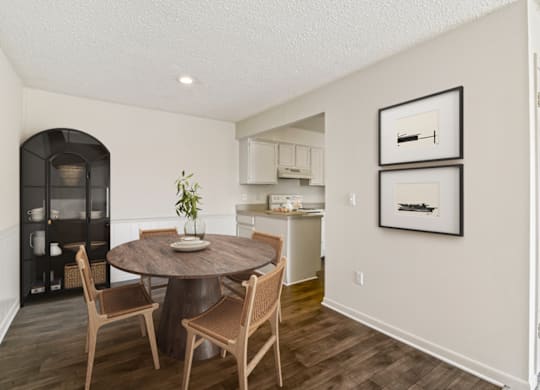 a dining area with a table and chairs and a kitchen in the background at Eastchester Ridge Apartments, High Point, North Carolina
