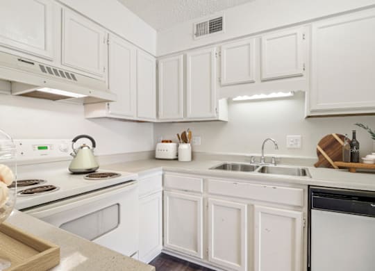 a kitchen with white cabinets and white appliances at Eastchester Ridge Apartments, High Point