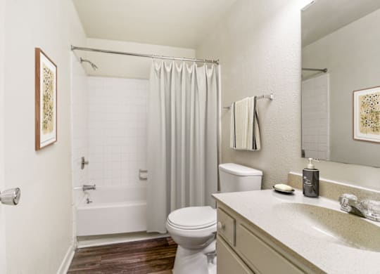 a bathroom with a white bathtub and a white toilet next to a white sink at Eastchester Ridge Apartments, North Carolina