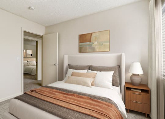 a bedroom with a bed and a nightstand with a lamp at Eastchester Ridge Apartments, High Point, North Carolina