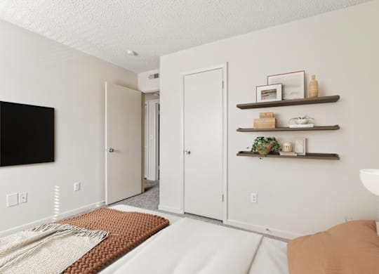a bedroom with a bed and a tv on the wall at Eastchester Ridge Apartments, North Carolina
