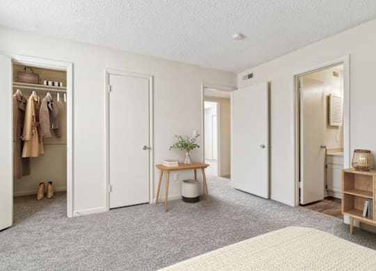 a bedroom with three doors and a table with a plant on it at Eastchester Ridge Apartments, North Carolina