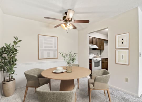 a dining room with a ceiling fan and three chairs at Eastchester Ridge Apartments, High Point, NC