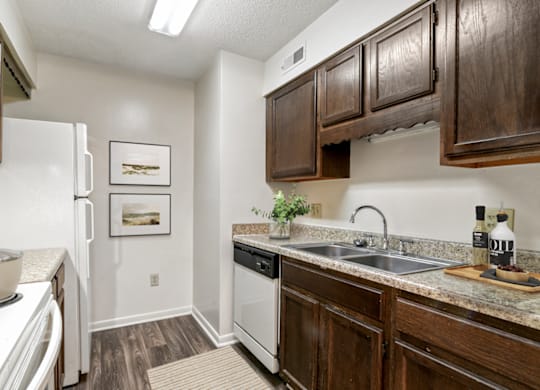 a kitchen with dark wood cabinets and white appliances at Eastchester Ridge Apartments, High Point, 27262