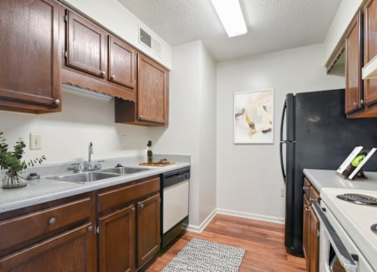 a kitchen with dark wood cabinets and white appliances at Eastchester Ridge Apartments, High Point, NC