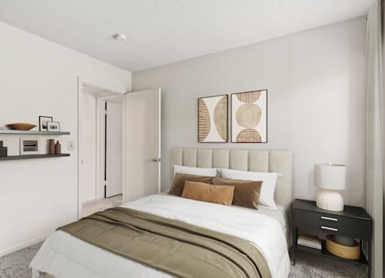 a bedroom with white walls and a white bed with brown pillows at Eastchester Ridge Apartments, High Point, NC