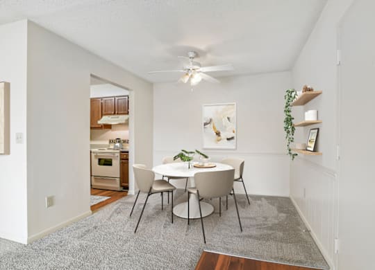 a dining area with a white table and chairs and a ceiling fan at Eastchester Ridge Apartments, High Point, North Carolina
