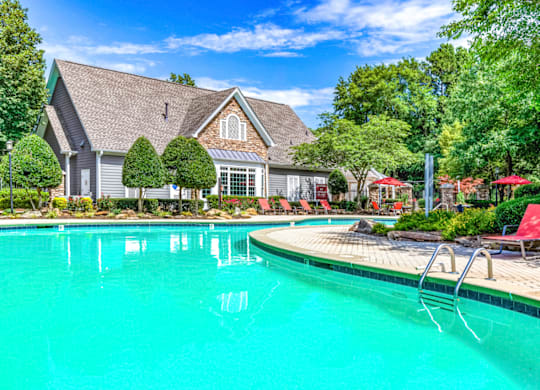 a swimming pool with a house in the background