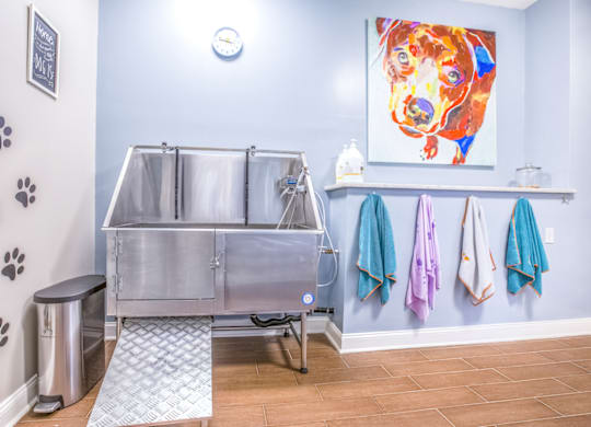 a stainless steel sink in a bathroom with a colorful painting on the wall