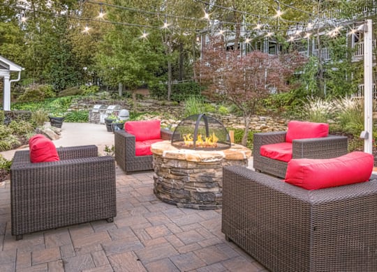 a patio with a fire pit and wicker furniture