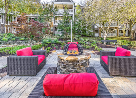 a seating area with a fire pit in the middle of a brick patio