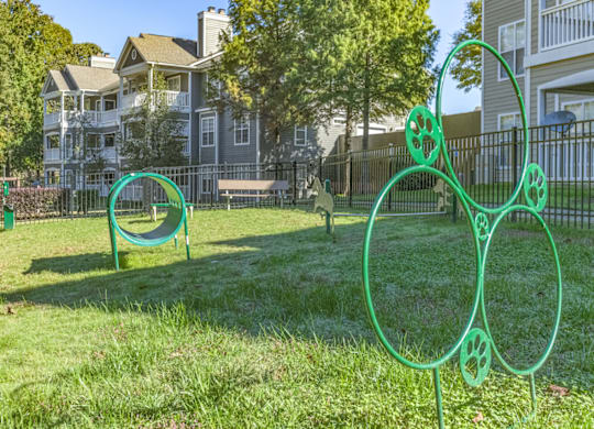 a park with a seesaw in the foreground and houses in the background