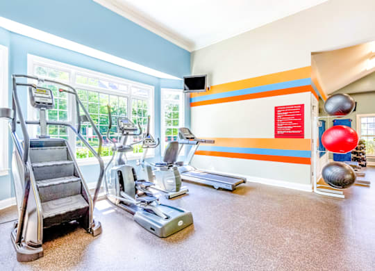 a workout room with treadmills and other exercise equipment