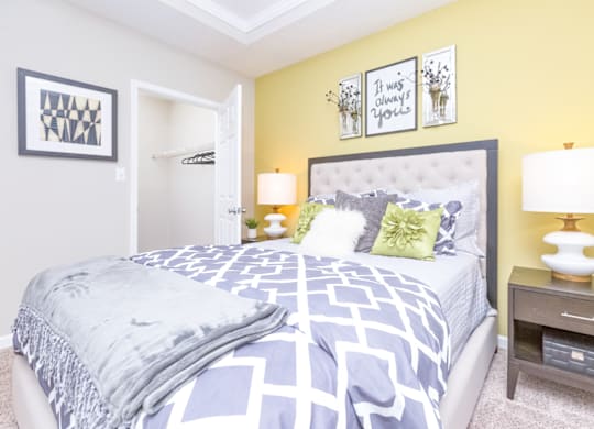 a bedroom with yellow walls and blue and white bedding