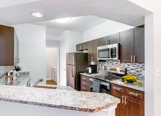 a kitchen with granite countertops and wooden cabinets