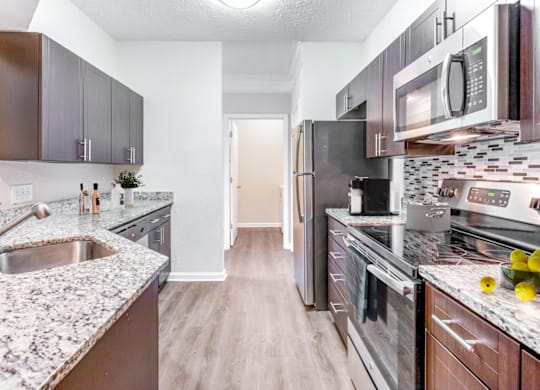 a kitchen with granite countertops and stainless steel appliances