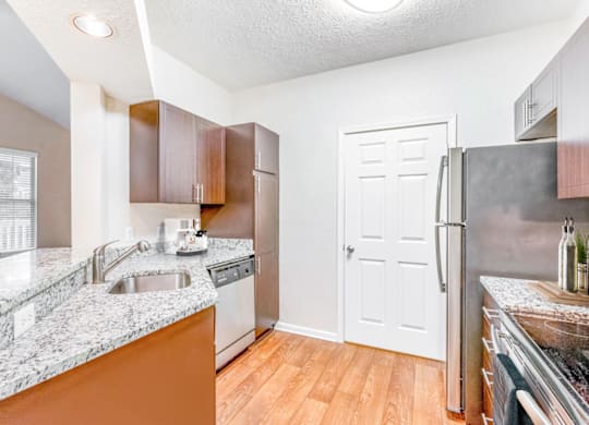 a kitchen with granite countertops and stainless steel appliances