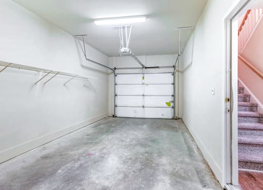 a white garage with a white wall and a white ceiling with a fluorescent light