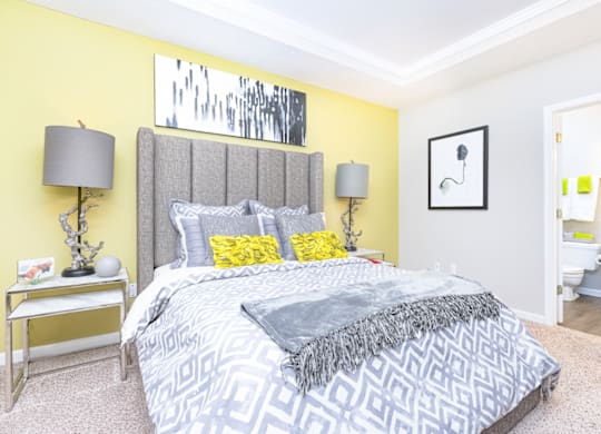 a bedroom with yellow walls and a gray bed