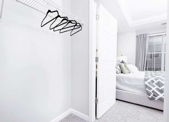 A white bedroom with a bed and a white wall.